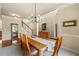 Inviting dining room with modern chandelier, wood table, and staircase leading to the upper level at 1995 Settindown Dr, Roswell, GA 30075