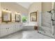 Modern main bathroom with marble floors, double vanity, tub, and glass shower at 1995 Settindown Dr, Roswell, GA 30075