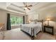Main bedroom featuring a tray ceiling, ceiling fan, and large window at 1995 Settindown Dr, Roswell, GA 30075