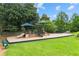 Community playground with swings, slides and other play structures surrounded by lush trees at 1995 Settindown Dr, Roswell, GA 30075