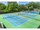 Community tennis courts showcasing multiple blue and green courts with lighting for evening play at 1995 Settindown Dr, Roswell, GA 30075