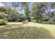 Large backyard with lush lawn and mature trees in a quiet setting at 33 Russell Rd, Mcdonough, GA 30252