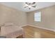 Cozy bedroom features wood flooring and a fun daisy wallpaper accent wall at 33 Russell Rd, Mcdonough, GA 30252
