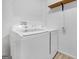 Efficient laundry area with a modern washer and dryer, and a functional storage shelf at 33 Russell Rd, Mcdonough, GA 30252
