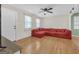 Bright living room featuring hardwood floors, large windows, and a cozy red sectional at 33 Russell Rd, Mcdonough, GA 30252