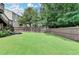 Lush backyard with green grass, wooden fence, and mature trees, offering a private outdoor space at 3845 Lake Lanier Dr, Duluth, GA 30097
