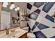 Stylish bathroom with modern fixtures, geometric accent wall, vanity, toilet and open shelving at 3845 Lake Lanier Dr, Duluth, GA 30097