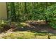 Backyard landscape with natural stone accents, mature trees, and verdant lawn at 77 Skyland Dr, Roswell, GA 30075