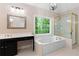 Sunlit bathroom with a shower, garden tub, black vanity, and a large window at 77 Skyland Dr, Roswell, GA 30075