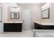 Well-lit bathroom with a double vanity, mirrors, and a tile floor at 77 Skyland Dr, Roswell, GA 30075