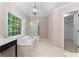 Bright bathroom featuring a garden tub, shower, and a window overlooking the backyard at 77 Skyland Dr, Roswell, GA 30075