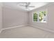 This bedroom features neutral paint, carpet, a ceiling fan, and windows with natural light at 77 Skyland Dr, Roswell, GA 30075