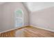 Bright bedroom with hardwood floors and a large arched window letting in natural light at 77 Skyland Dr, Roswell, GA 30075