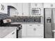 Updated kitchen showcases stainless appliances, mosaic backsplash, and white cabinetry at 77 Skyland Dr, Roswell, GA 30075
