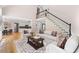 Bright and airy living room with hardwood floors, a fireplace, high ceilings, and staircase to the second level at 77 Skyland Dr, Roswell, GA 30075