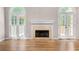 Bright and airy living room with hardwood floors, a fireplace, high ceilings, and French doors to the outdoors at 77 Skyland Dr, Roswell, GA 30075