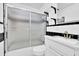 Bathroom showcasing shower with sliding doors, white cabinets, and black and white tiles at 91 Tatum St, Marietta, GA 30060