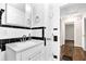Bathroom featuring a white vanity with black and white tiled walls and a decorative mirror at 91 Tatum St, Marietta, GA 30060