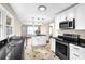 Bright kitchen featuring an island, black countertops, white cabinetry, and stainless steel appliances at 91 Tatum St, Marietta, GA 30060