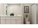 Bright bathroom with a double sink vanity, modern art, and a shower with a white curtain at 1817 Holmsey Se Cir, Conyers, GA 30094