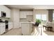 Well-lit kitchen features white cabinets, stainless steel appliances, a kitchen island, and sliding glass doors at 1817 Holmsey Se Cir, Conyers, GA 30094