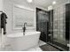 Modern bathroom with soaking tub and stand up shower featuring glass door and unique black tile at 1302 Ladd St, Atlanta, GA 30310