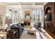 Cozy living room with fireplace, custom built-ins, and large windows offering wooded view at 2250 Blackheath Trce, Alpharetta, GA 30005