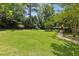 Expansive backyard featuring lush green lawn and mature trees, perfect for outdoor activities at 3500 Thunderwood Ln, Snellville, GA 30039