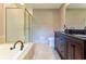 A primary bathroom features a double sink vanity, soaking tub and glass enclosed shower stall at 3500 Thunderwood Ln, Snellville, GA 30039