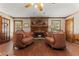Cozy living room with a brick fireplace, comfortable seating, and wood-look floors at 3500 Thunderwood Ln, Snellville, GA 30039