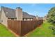 Fenced backyard view showing the lush green grass and siding of the home at 420 Spring Lake Ter, Covington, GA 30016