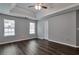 Bright bedroom features windows, dark wood floors, and a trey ceiling with a ceiling fan at 420 Spring Lake Ter, Covington, GA 30016