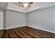 This bedroom features wood-look floors, a door and two windows, and a tray ceiling with ceiling fan at 420 Spring Lake Ter, Covington, GA 30016