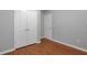 This gray bedroom offers wood-look floors, double doors to closet, and white door to another room at 420 Spring Lake Ter, Covington, GA 30016