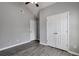 Neutral bedroom features vaulted ceiling, gray walls, dark wood-look floors, and double door closet at 420 Spring Lake Ter, Covington, GA 30016