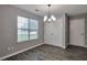 The dining room is equipped with wood-look floors, a window, and modern lighting fixture at 420 Spring Lake Ter, Covington, GA 30016