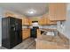 Functional kitchen featuring light wood cabinets and modern black appliances at 420 Spring Lake Ter, Covington, GA 30016