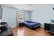 Bedroom with light-blue walls, wood-look flooring, and a window that provides natural light at 580 Lilburn School Rd, Lilburn, GA 30047