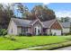 Single-story home featuring a brick facade, bay window, and lush green lawn at 580 Lilburn School Rd, Lilburn, GA 30047