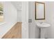 Bright powder room featuring a pedestal sink and decorative mirror at 2472 Cotton Ln, Douglasville, GA 30135