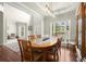 Bright dining room boasts tall windows, hardwood floors, decorative china cabinet, and modern light fixture at 3070 Jardin Nw Ln, Kennesaw, GA 30152