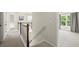 Upstairs hallway with carpet, wooden railing, a large window, and views of the adjacent rooms at 3070 Jardin Nw Ln, Kennesaw, GA 30152