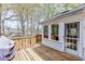 Wooden back deck with grill, access door, and scenic views of the surrounding greenery at 1545 Smoke Hill Dr, Hoschton, GA 30548