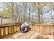 Spacious wooden back deck featuring an outdoor grill and serene wooded views at 1545 Smoke Hill Dr, Hoschton, GA 30548