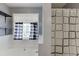 Bright bathroom featuring a tiled bathtub and a shower with black-and-white checkered curtains at 1545 Smoke Hill Dr, Hoschton, GA 30548