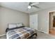 Bedroom featuring a ceiling fan, and a comfortable bed with a plaid blanket and white pillows at 1545 Smoke Hill Dr, Hoschton, GA 30548