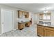 Classic kitchen with wooden cabinets and granite countertops featuring a built-in desk area, plus a view into other rooms at 1545 Smoke Hill Dr, Hoschton, GA 30548