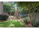 Backyard featuring a wooden playset with swings and slide, set amongst mature trees and flowering bushes at 2023 Belridge Se Ct, Smyrna, GA 30080