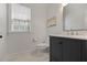 Well-lit bathroom features a dark vanity, tile floors, and a modern mirror at 2023 Belridge Se Ct, Smyrna, GA 30080