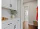 Mud room with custom white cabinets and drawers, next to door and bench with wood floors at 2023 Belridge Se Ct, Smyrna, GA 30080